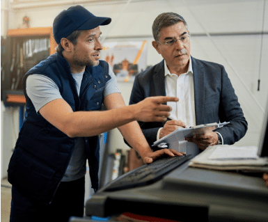 een man in pak en een man in werkkleding zijn aan het overleggen