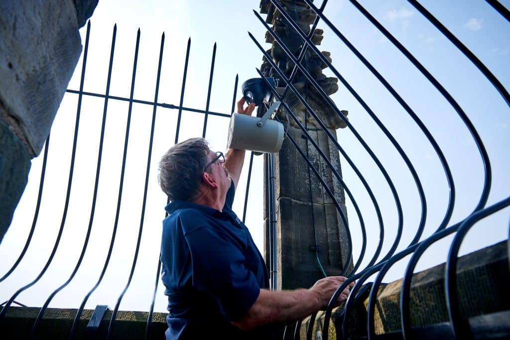 man die een beveiligingscamera aan het installeren is